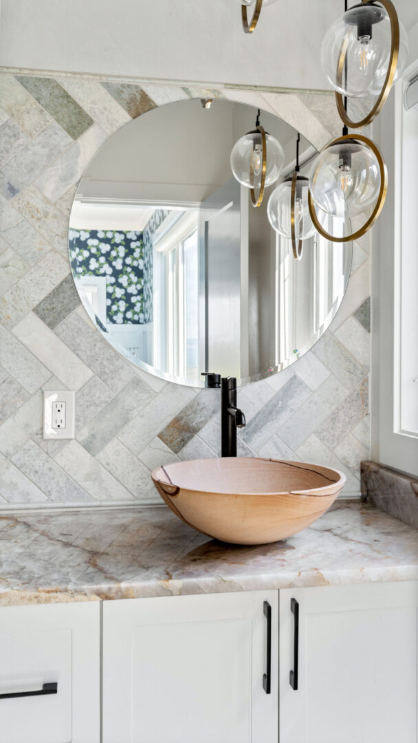 A bowl sink sitting under a mirror in the bathroom.