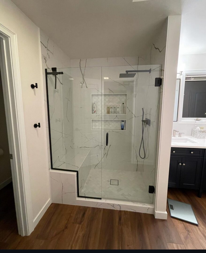 Completed Lion Heart marble shower with black hardware and a bench.