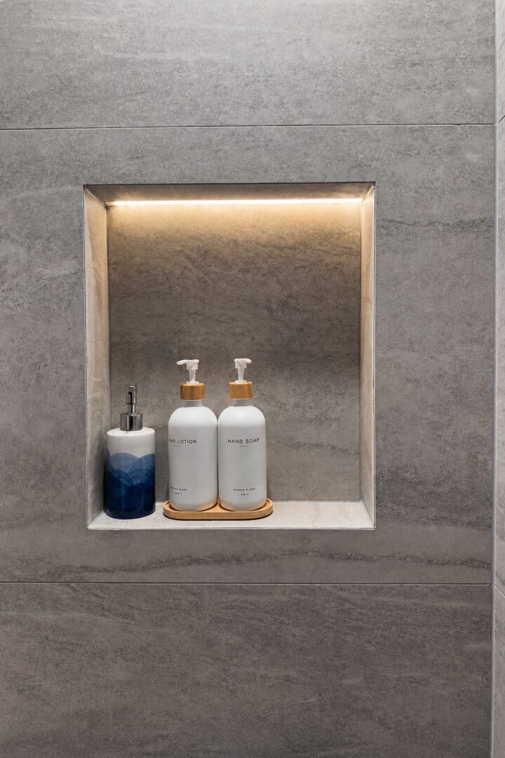Completed Lion Heart shower niche with stone tile and warm lighting.