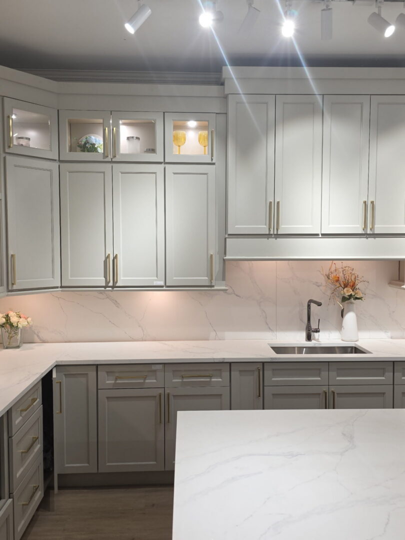 Completed Lion Heart kitchen with light cabinetry, brass pulls, and a quartz island.